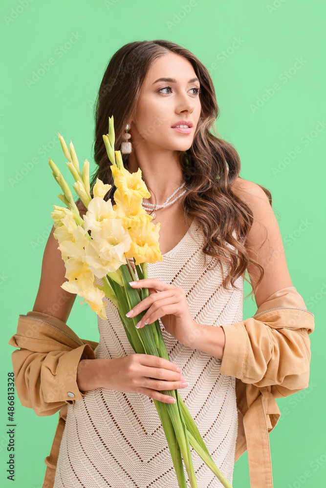 优雅的女人，带着一束唐菖蒲花，望向绿色背景
