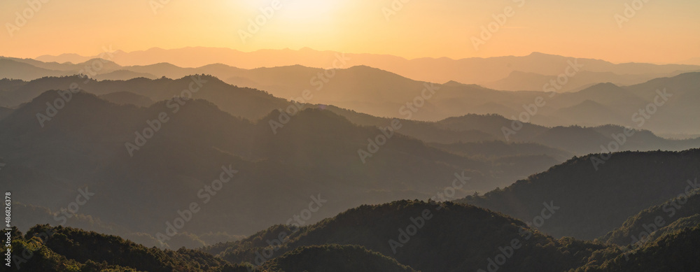 Beautiful dark orange mountain landscape with fog and forest. sunrise and sunset in mountains, Layer