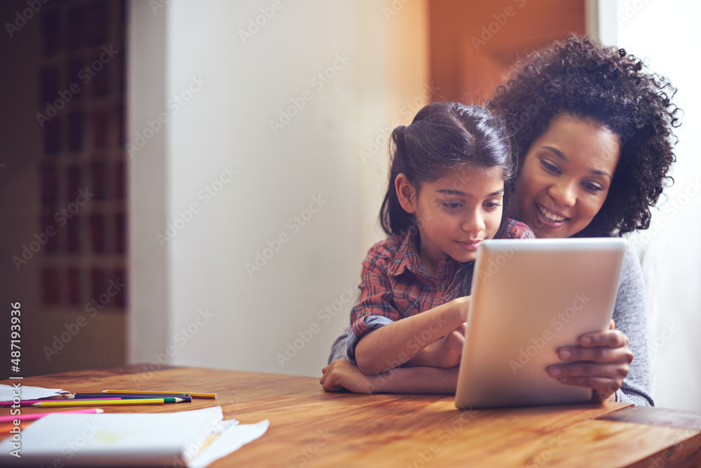 与妈妈一起探索网络世界。一对母女一起使用数字平板电脑的照片