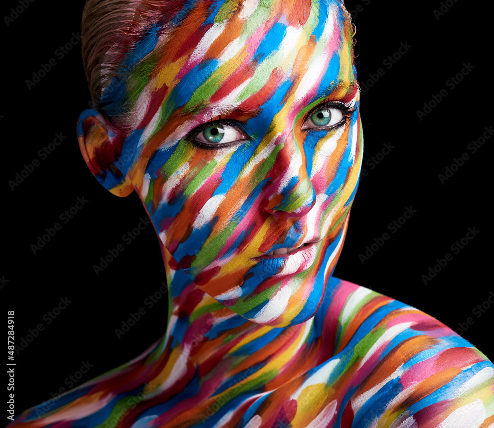 色彩艳丽。一位年轻女子的裁剪肖像，脸上涂着颜料。