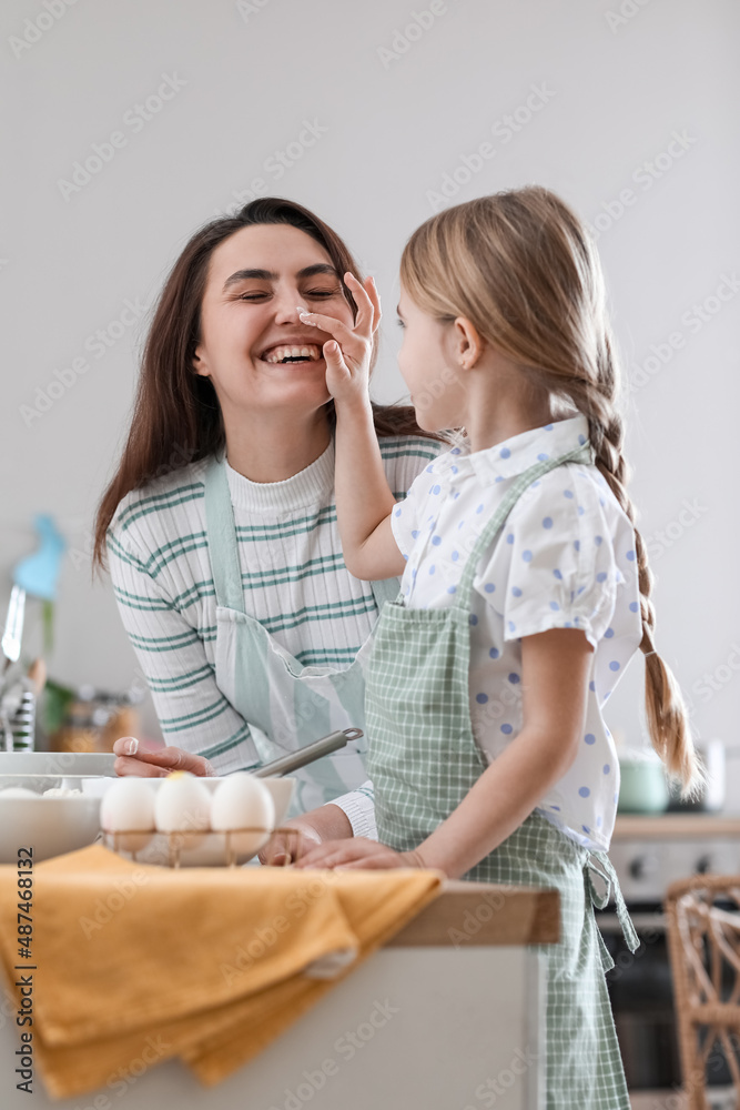 复活节那天，小女孩在厨房做饭时摸妈妈的鼻子