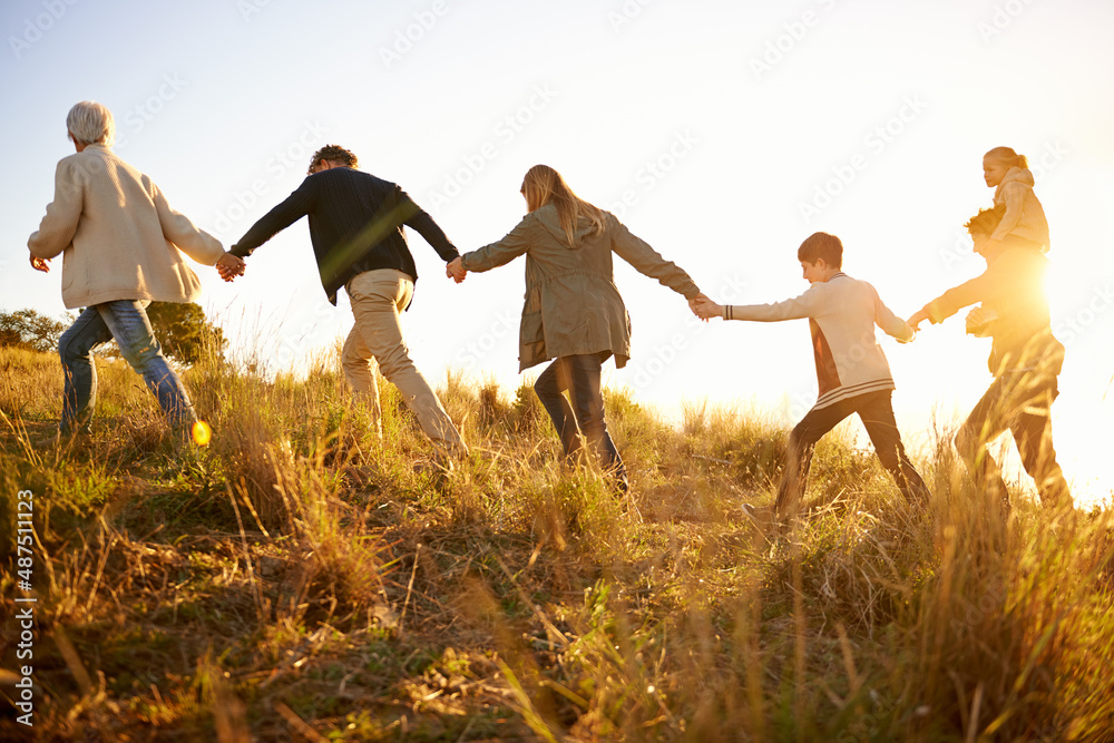 彼此都很安全。一个幸福的家庭早上一起牵手散步的照片。