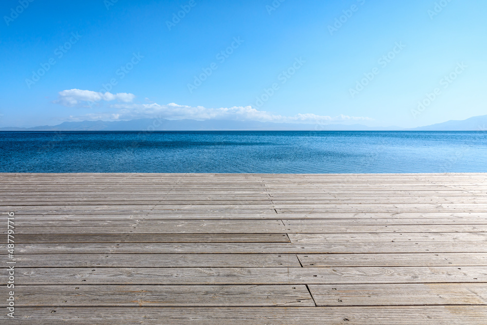 Wooden floor and azure lake natural landscape under blue sky