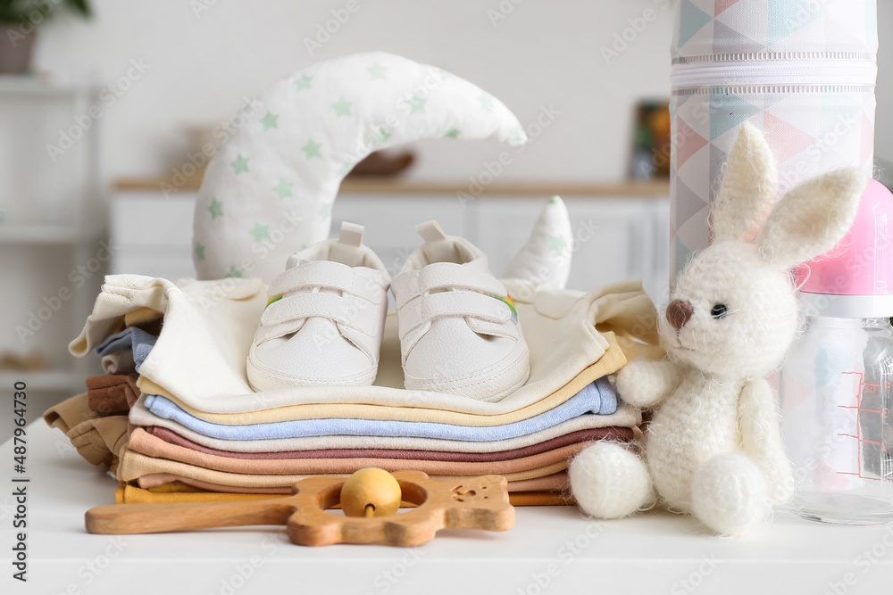 白色桌子上的婴儿衣服、鞋子和玩具堆