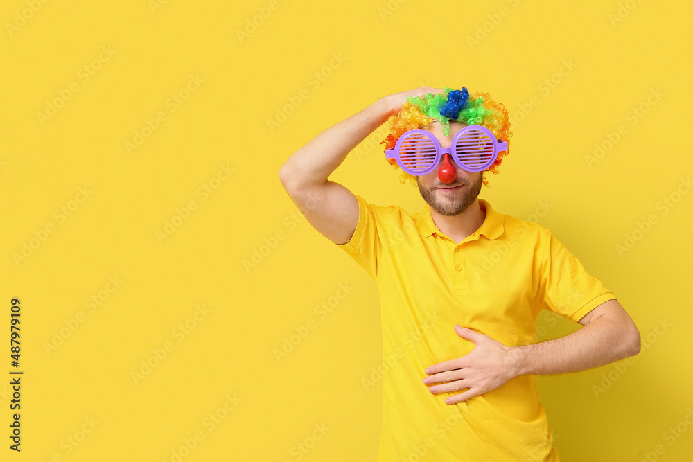 黄色背景下乔装打扮的有趣年轻人。愚人节庆祝活动