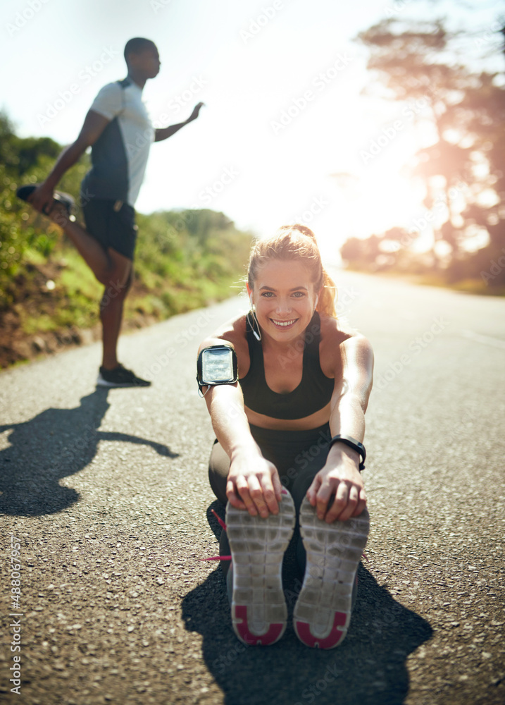 为一次惊人的锻炼做好肌肉准备。一名年轻女子在户外跑步前拉伸的照片