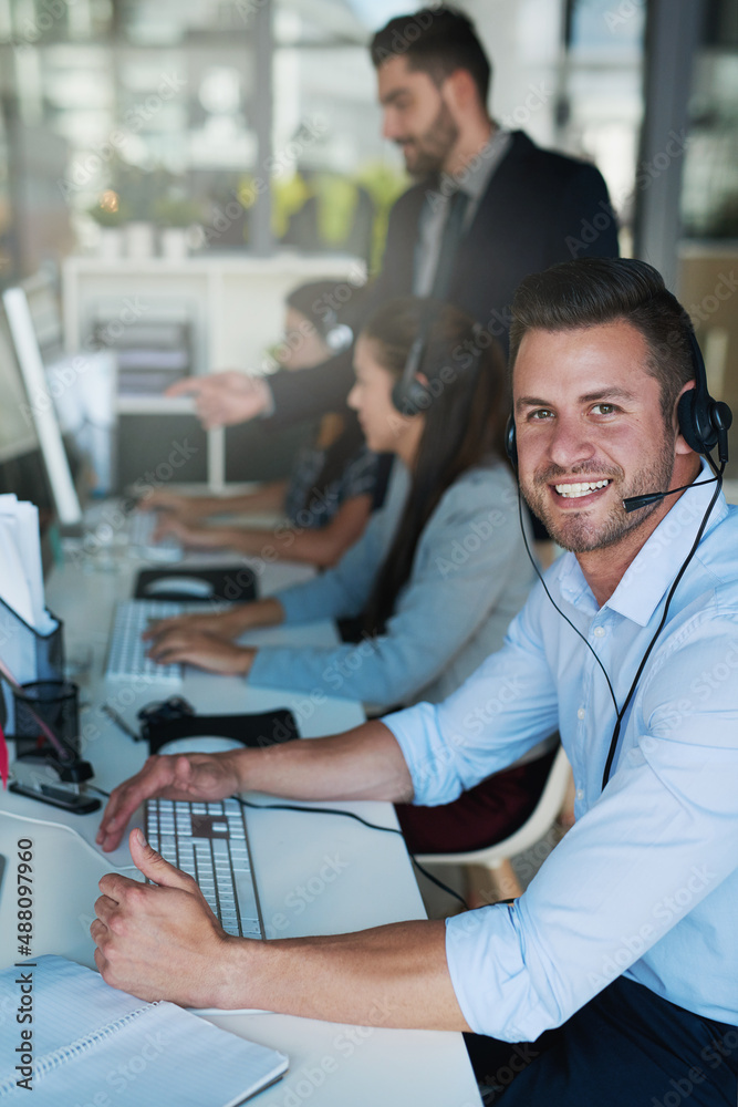Support with a smile. Portrait of a happy and confident young man working in a call center.