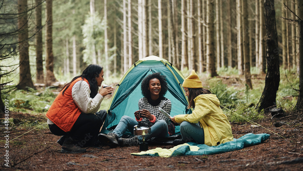 Women sitting at their campsite in the woods