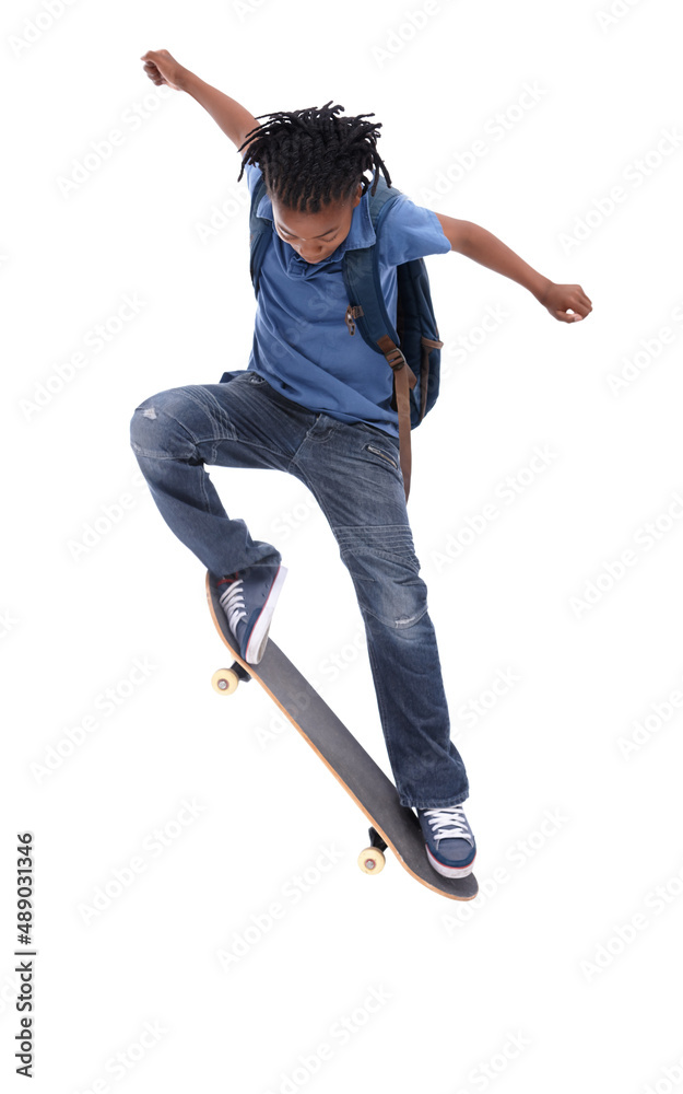 炫耀他的疯狂技能。一个年轻的非裔美国男孩在滑板上玩把戏。