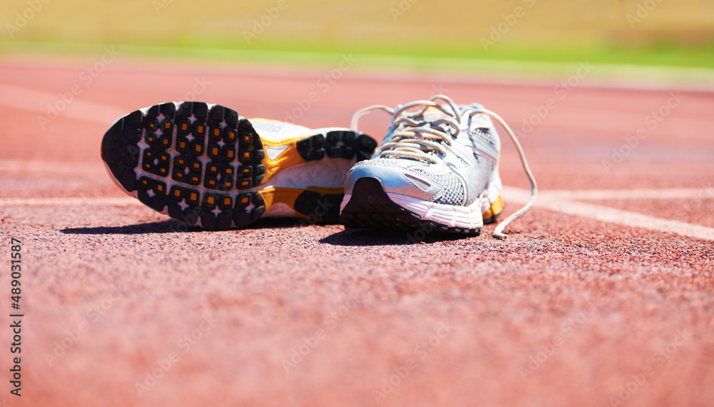从比赛中休息一下。一双跑鞋躺在跑道上。