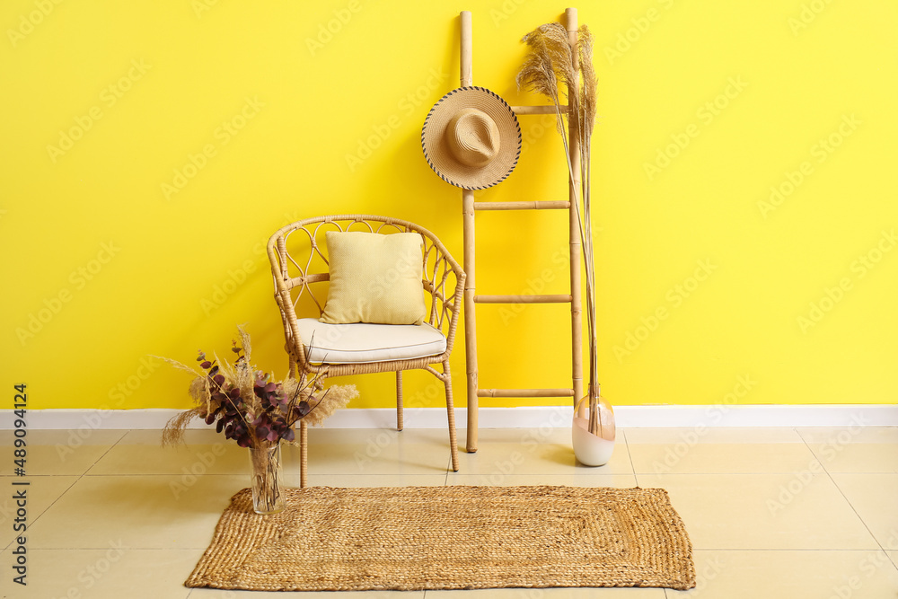 房间内部配有柳条椅、梯子和靠近彩色墙的时尚地毯