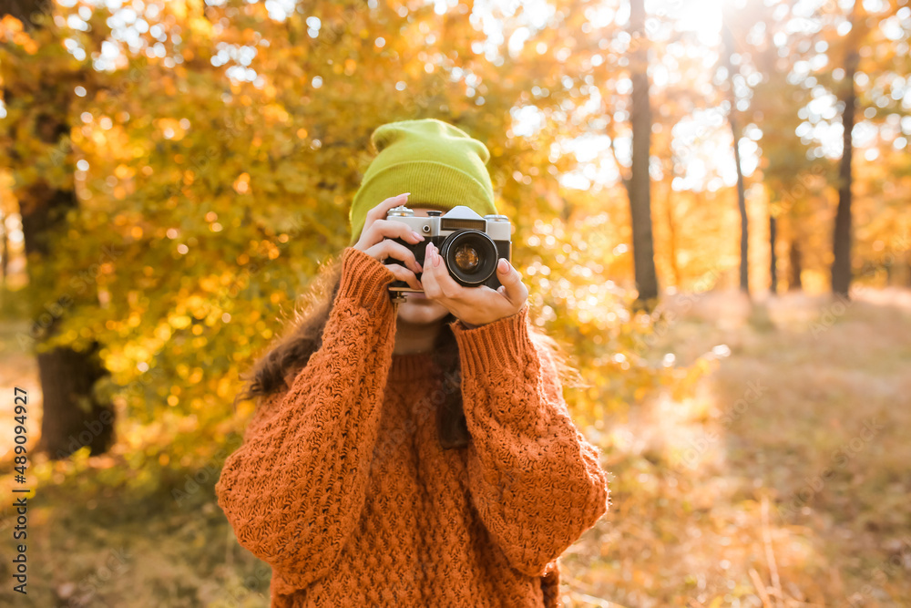 年轻女子在秋天的森林里拍照