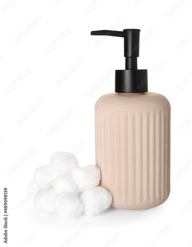 Soft cotton balls and bottle of cosmetic products on white background