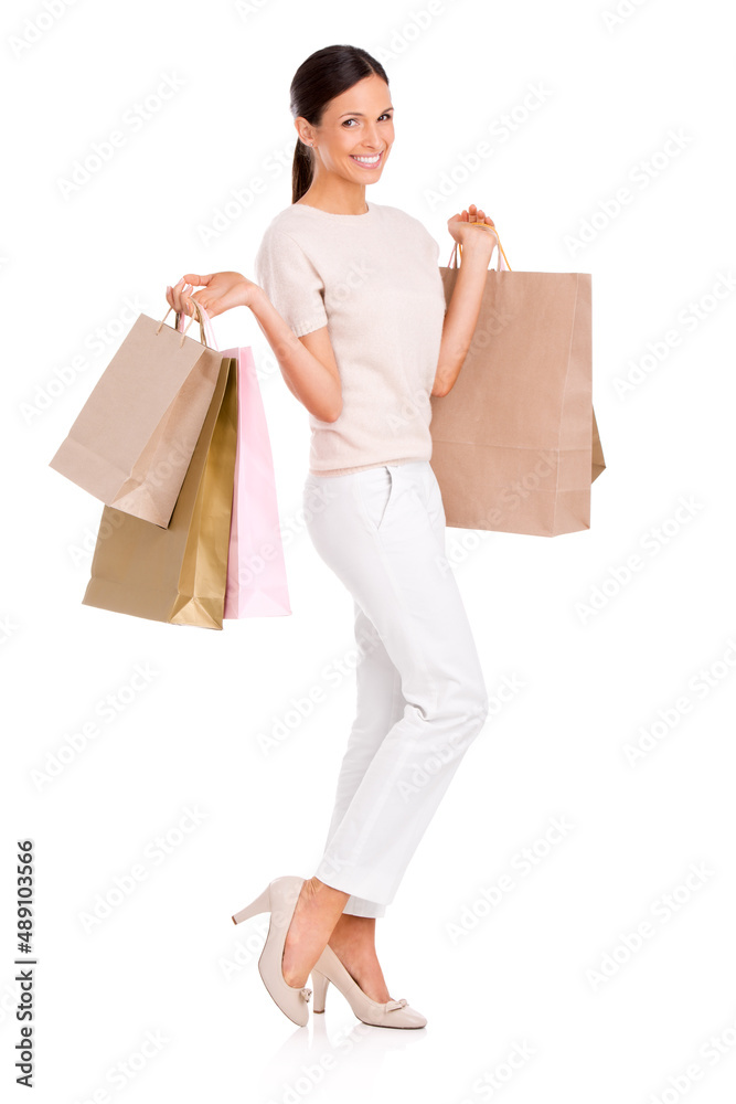 Have I got something for you. Full-length studio portrait of an attractive young woman holding shopp