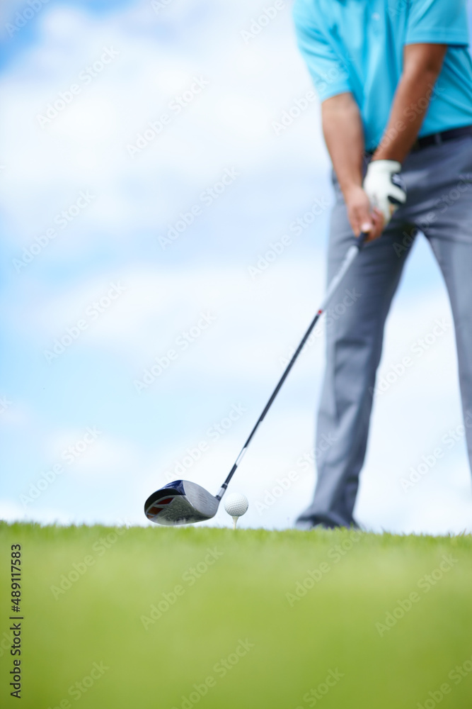 Grounding the club. Cropped image of a young male golfer teeing up to play a shot with his driver.