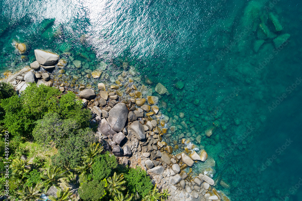 海浪拍打着椰子树的岩石的鸟瞰图普吉岛美丽的海滨