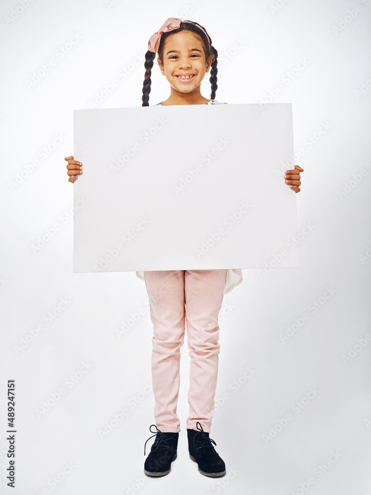 This one is for all the kids. Studio shot of an adorable little girl holding a blank placard.