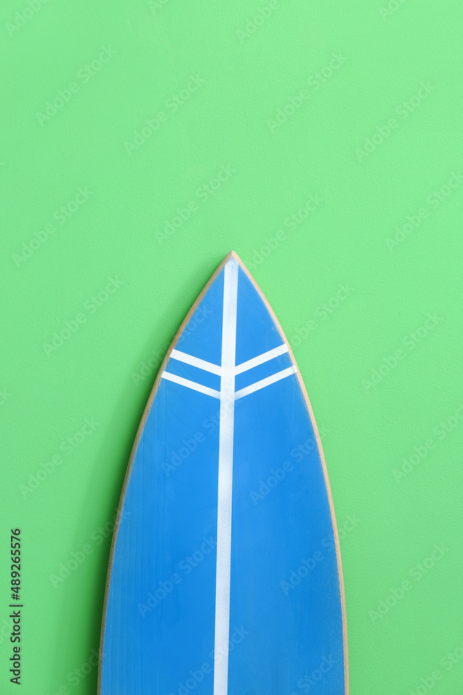 Modern surfboard near green wall