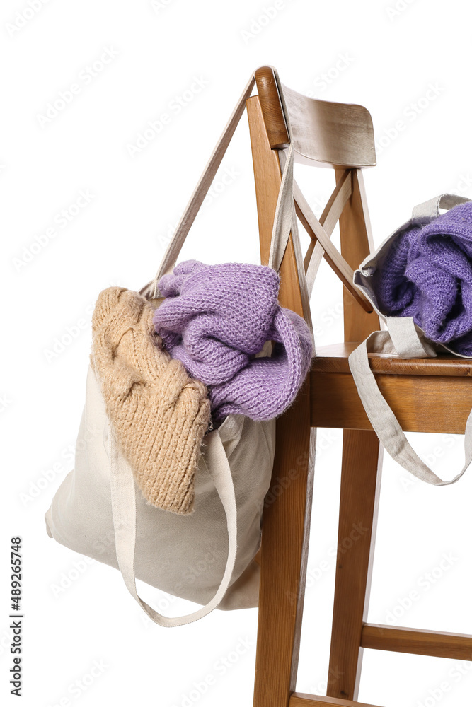 白色背景木椅上的编织毛衣袋子