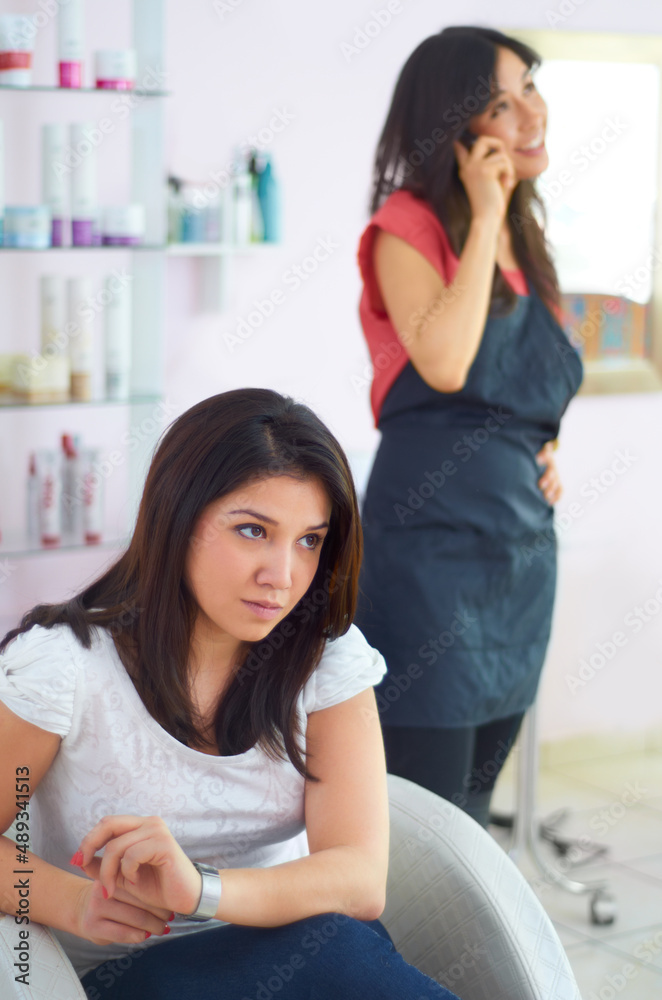 是时候换一个新发型师了。一位年轻女子在等待造型师完成发型时看起来很生气