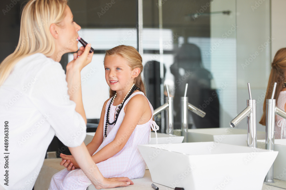 I cant wait to wear my own make-up. Little girl watching her mother apply her make-up.