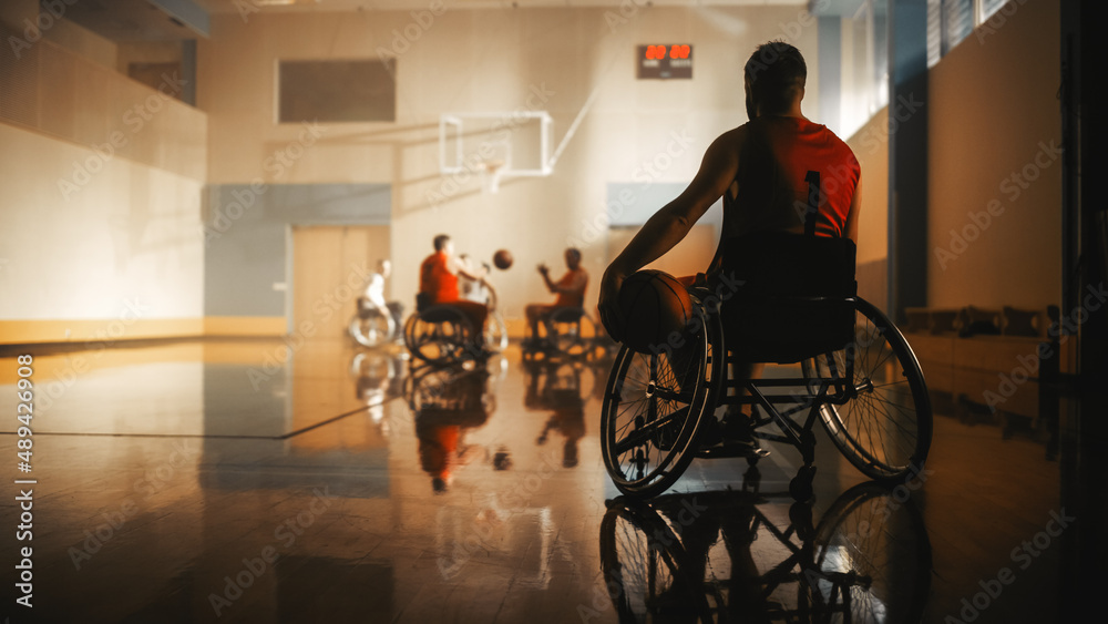 轮椅篮球赛：身穿红衫的球员持球等待轮到他。运动员Watc