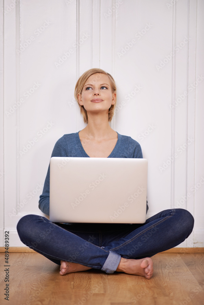 Whats on my mind today. Shot of a beautiful woman sitting on the floor using a laptop.