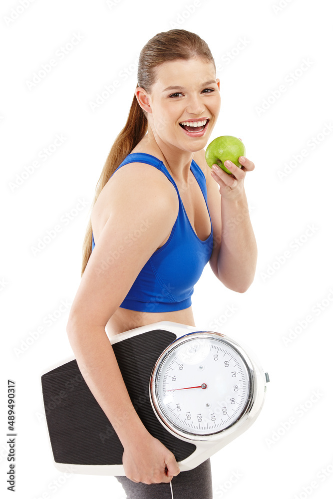 A pretty teenager holding an apple in her hand while carrying a scale. A pretty teenager holding an 