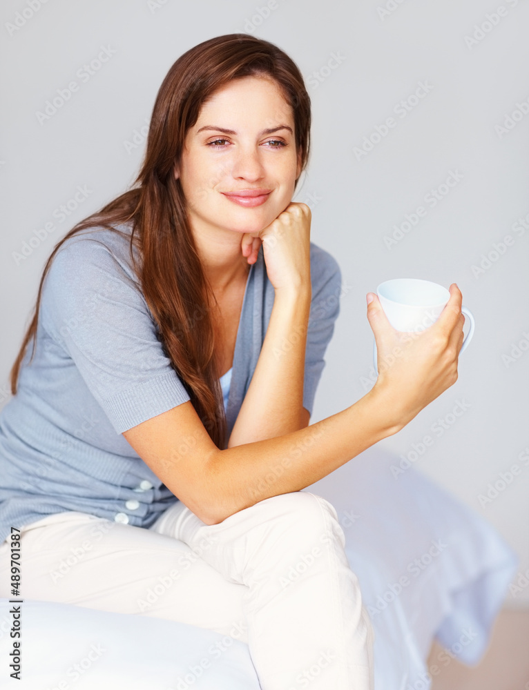 体贴的女性在卧室喝一杯咖啡。白日梦——很随意的女性饮料