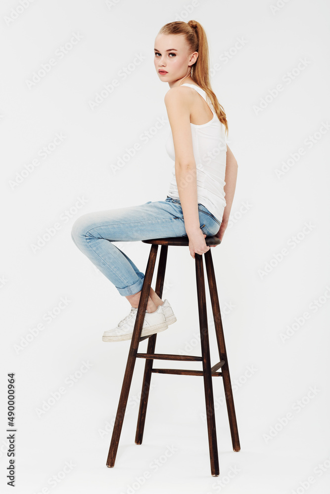 The royal chair. Portrait of a beautiful young woman on a chair isolated on white.