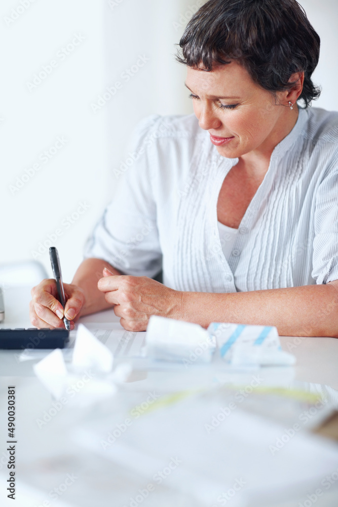 忙着计算税款。成熟的女性高管在办公室里忙着计算税收。