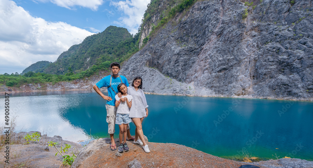 Family people standing near the pond or lake in tropical rainforest with mountain rocks peak Beautif