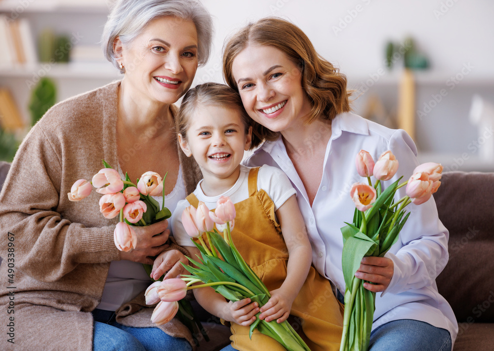 国际妇女节快乐。微笑的家庭祖母，带着鲜花的母女chee
