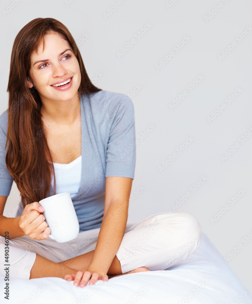可爱放松的女性喝着咖啡，若有所思地把目光移开。坐在腿上的快乐体贴的女性