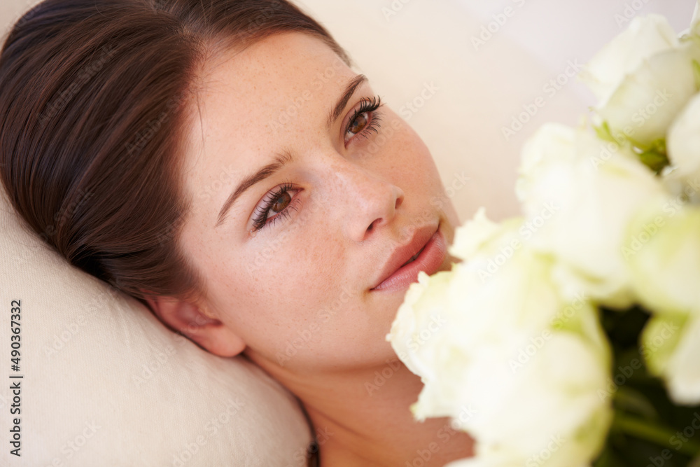 坠入爱河。一个美丽的年轻女人躺下来，手里拿着一束白玫瑰。