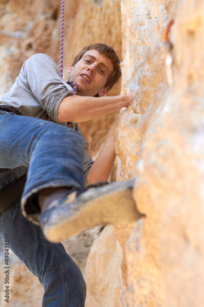 悬崖攀登者。一位年轻的攀岩者在攀岩岩壁上的肖像。