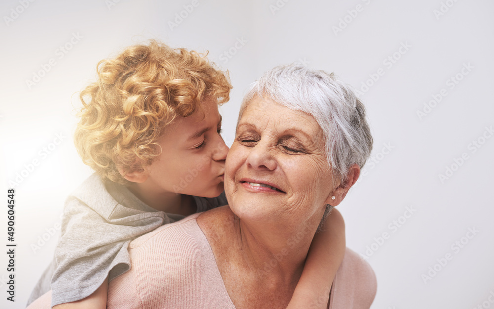 太爱你了，奶奶。一个小男孩亲吻奶奶脸颊的镜头。