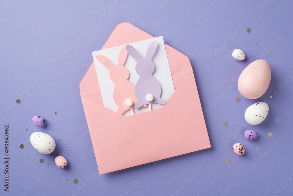 可爱的粉红色信封明信片的俯视图，里面有圆尾巴和棍子的奇妙纸兔子