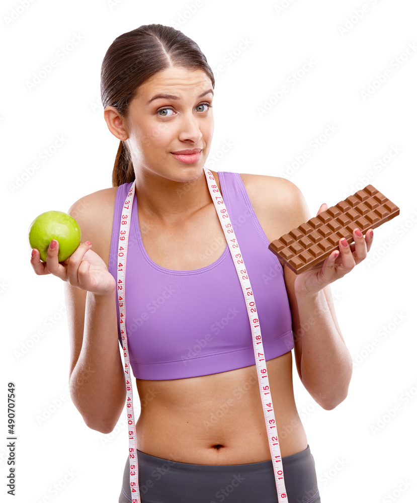选择权在你。一个健康的年轻女人一只手拿着苹果，另一只手抓着巧克力的照片