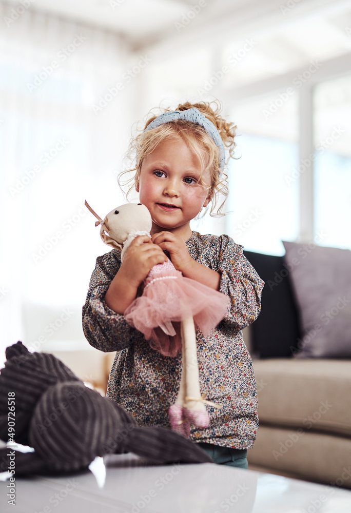 这是我最喜欢的玩具。一个可爱的小女孩独自站在客厅的裁剪镜头