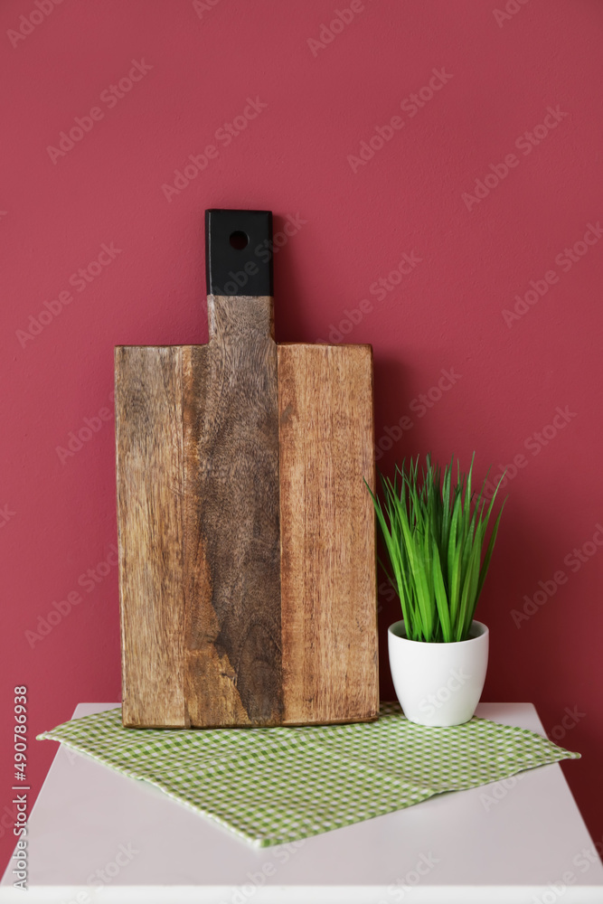 红墙附近桌子上的木制砧板和室内植物