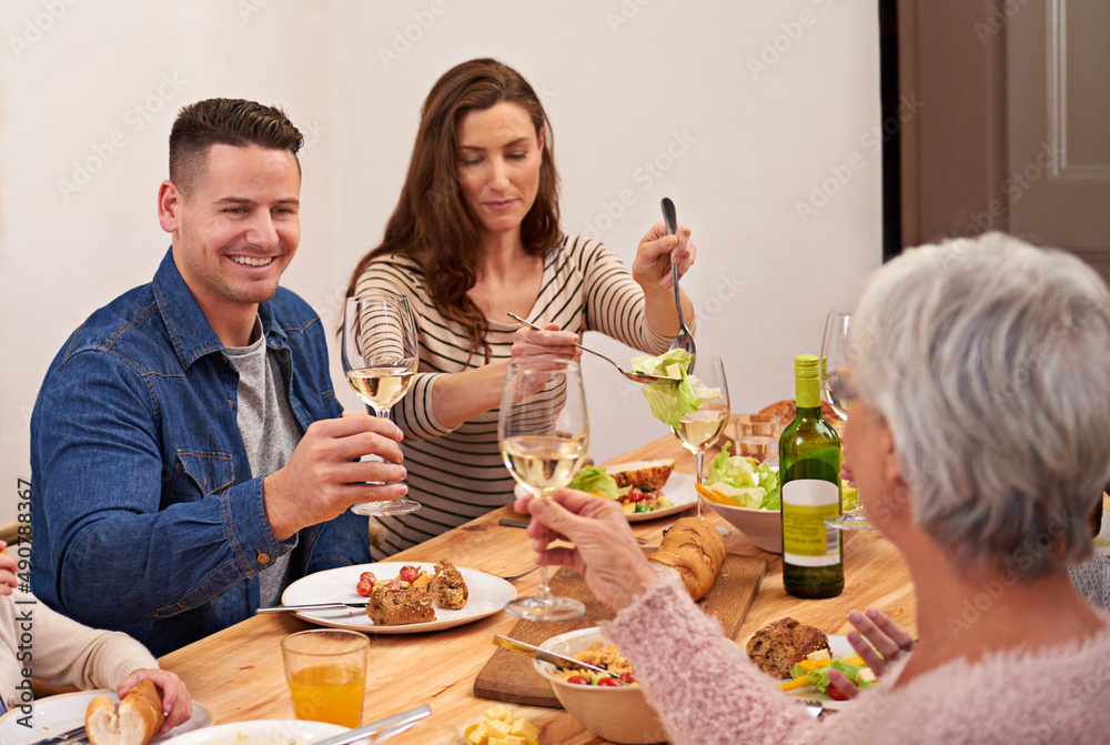 干杯。一家人在餐桌旁共享一顿饭的裁剪镜头。