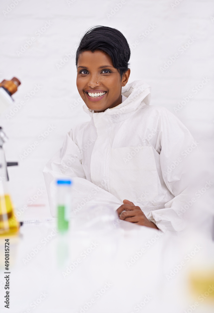 一个有成就感的职业。一个快乐的年轻科学家坐在实验室里的画像。