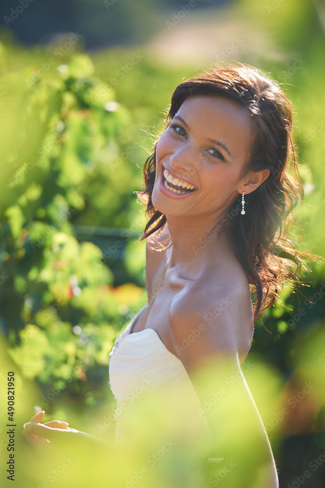 微笑的新娘。一个美丽的新娘站在葡萄园里微笑。