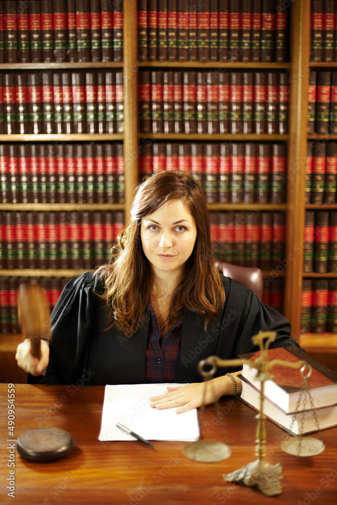 她是法律界的专家。一张年轻的法律专业人士坐在桌子旁研究的照片