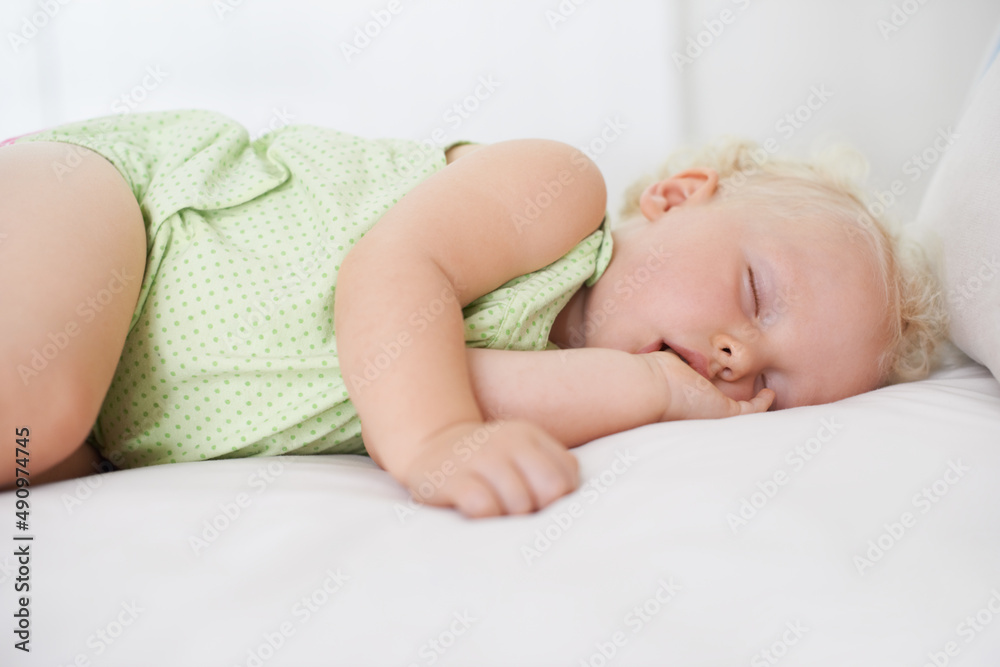 迷失在梦境中。一个可爱的女婴嘴里含着拇指熟睡。