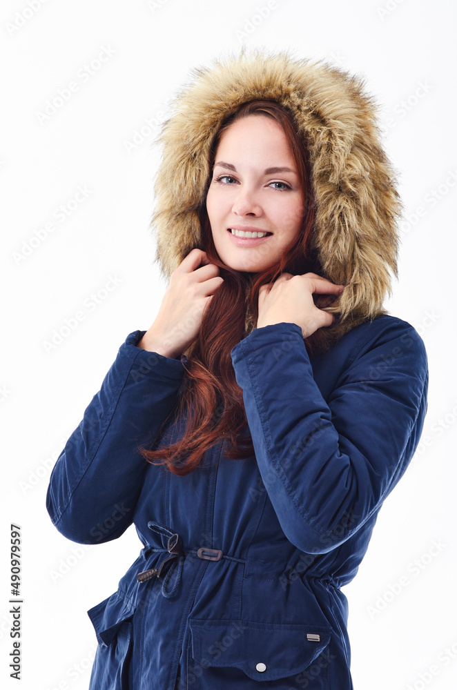 脱下你的冬季装备。一个年轻人穿着冬季夹克，背对白色背心的工作室肖像