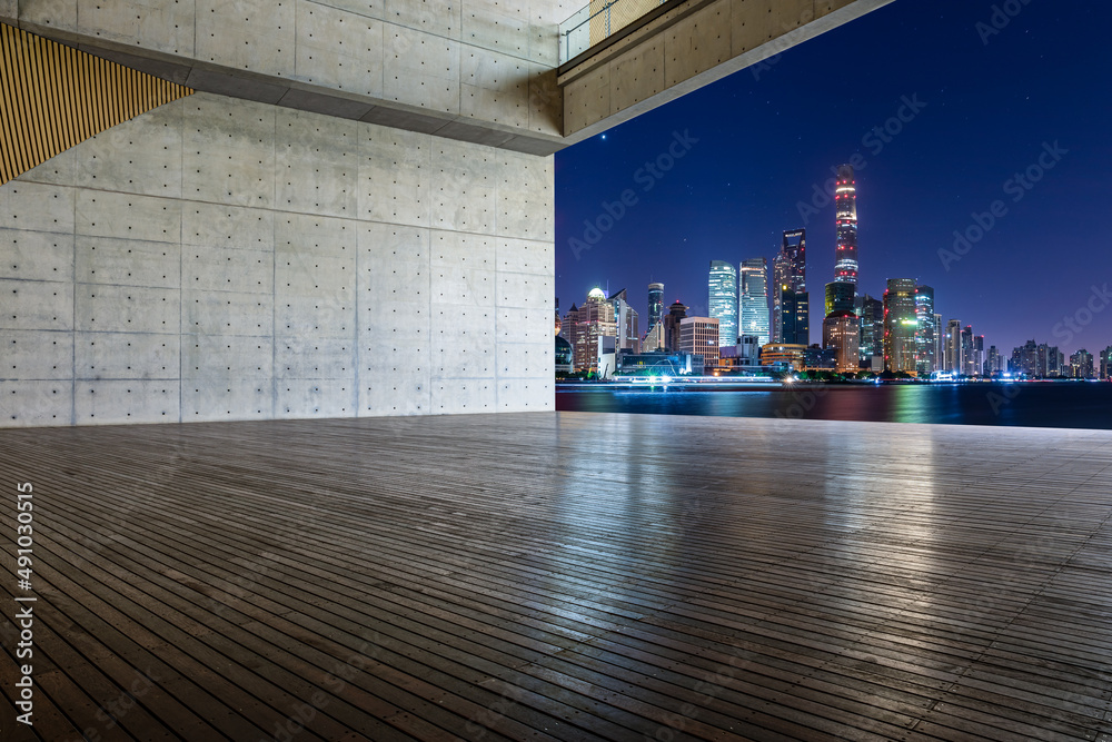 中国，夜晚的上海，空旷的木板广场和城市天际线。