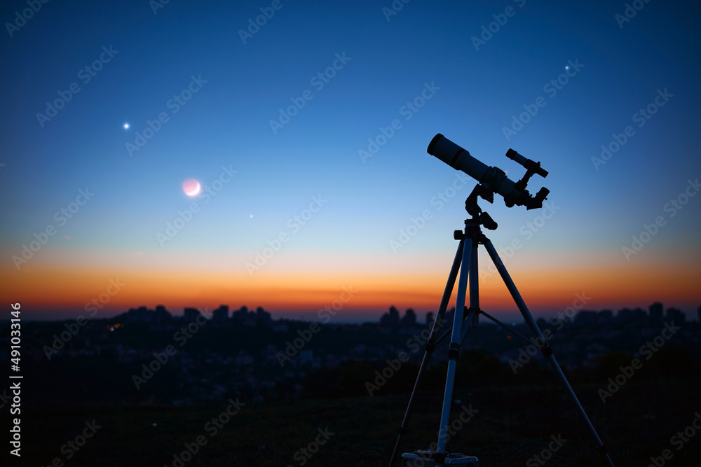 黄昏天空下的天文望远镜，准备观星。