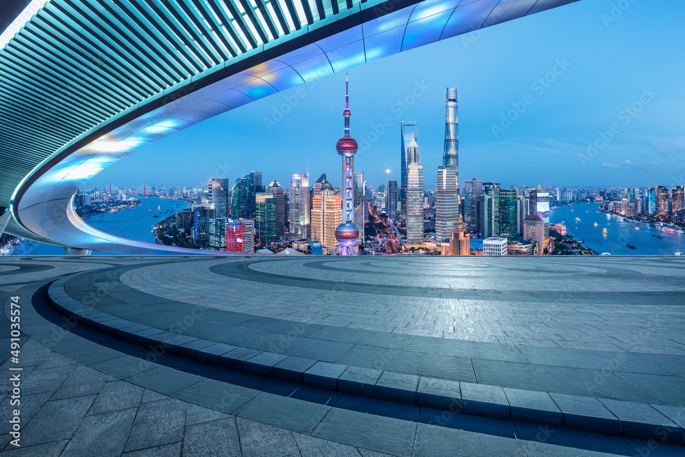 中国，夜晚的上海，空旷的广场层和城市天际线。